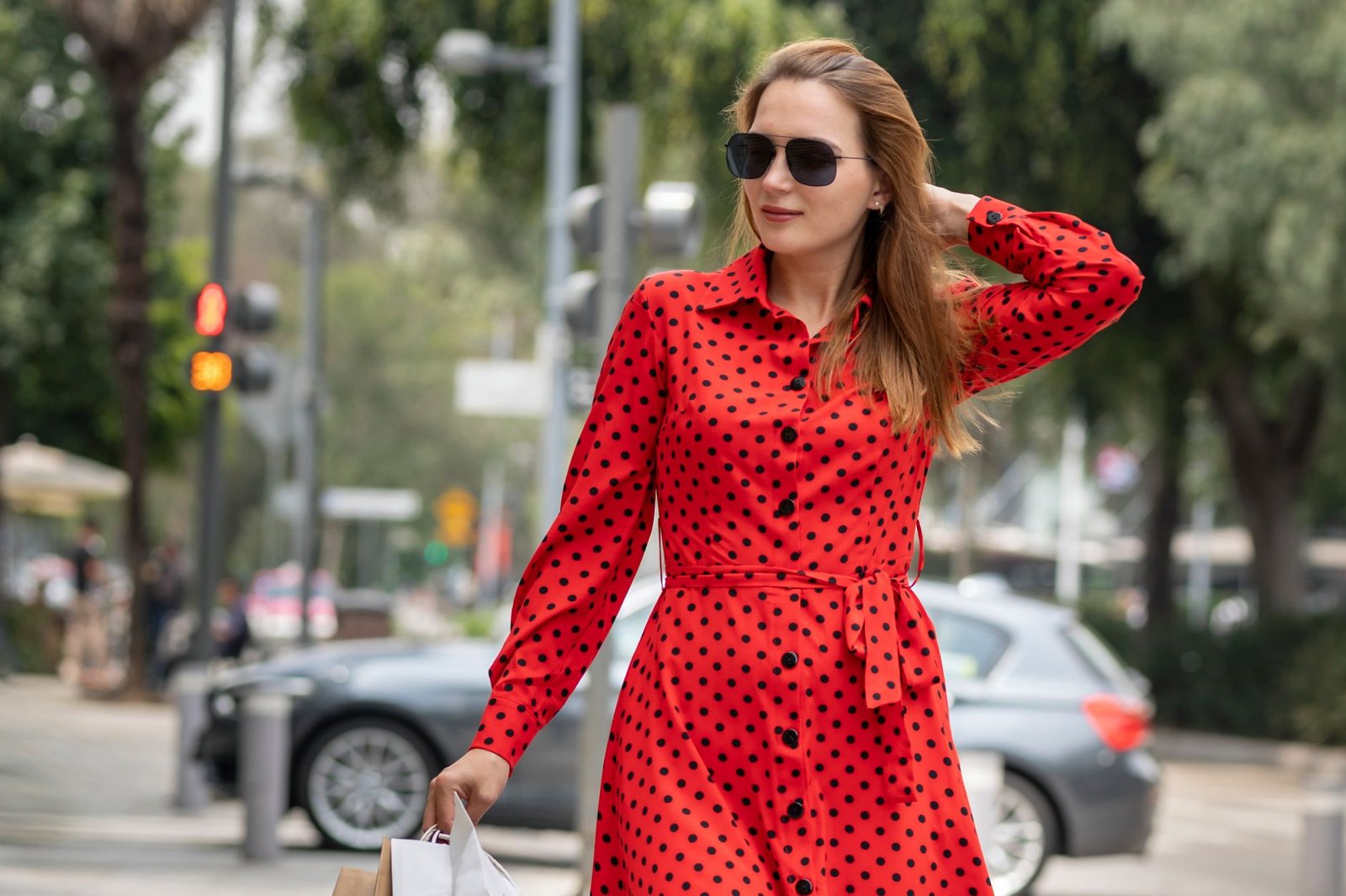 beautiful-woman-red-summer-dress-walking-joyfully-smiling-down-street-while-doing-shopping-carrying-her-bags